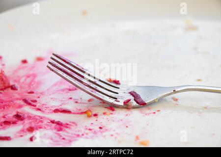 Resti di cibo, piatti sporchi dopo l'insalata con barbabietole e forchetta da vicino, piatti sporchi Foto Stock