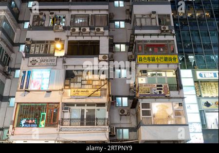Foot spa e altri cartelli per negozi su un alto edificio in Lockhart Road nella Baia di Causeway di notte. Hong Kong - 28 agosto 2023 Foto Stock