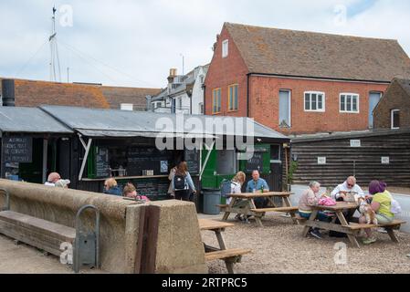 Gente che mangia al fast fish food tradizionale ristorante locale a Whitstable Harbour, Regno Unito. Foto Stock