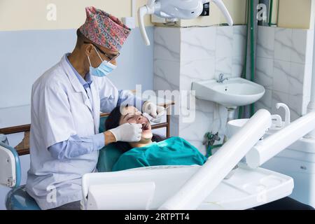 Kathmandu, Nepal - 02 settembre 2023: Un dentista nepalese che cura il suo paziente in un ospedale odontoiatrico Foto Stock