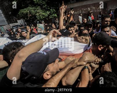 Gaza, Palestina. 14 settembre 2023. (NOTA DELL'EDITORE: L'immagine raffigura la morte)i pianti palestinesi portano il corpo del giovane, Muhammad Qaddum, durante la sua cerimonia funebre. Il Ministero della salute palestinese ha detto che almeno 5 persone sono state martirizzate e un certo numero di altre sono state ferite a seguito dell'esplosione che si è verificata vicino alla recinzione di separazione lungo il confine con Israele, a est della città di Gaza. Credito: SOPA Images Limited/Alamy Live News Foto Stock