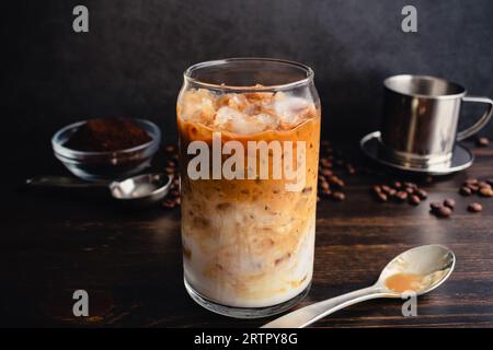 Caffè yogurt vietnamita (sua Chua Cafe o Cà Phê Sữa): Un bicchiere di caffè vietnamita ghiacciato con yogurt strained con un cucchiaio e filtro phin Foto Stock