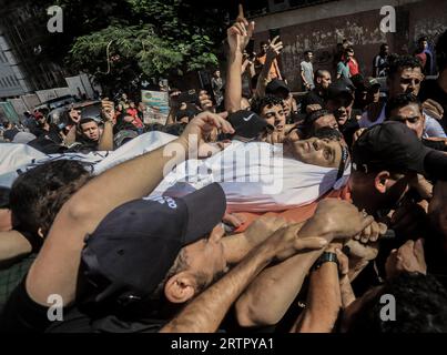 Gaza, Palestina. 14 settembre 2023. (NOTA DELL'EDITORE: L'immagine raffigura la morte)i pianti palestinesi portano il corpo del giovane, Muhammad Qaddum, durante la sua cerimonia funebre. Il Ministero della salute palestinese ha detto che almeno 5 persone sono state martirizzate e un certo numero di altre sono state ferite a seguito dell'esplosione che si è verificata vicino alla recinzione di separazione lungo il confine con Israele, a est della città di Gaza. (Foto di Yousef Masoud/SOPA Images/Sipa USA) credito: SIPA USA/Alamy Live News Foto Stock