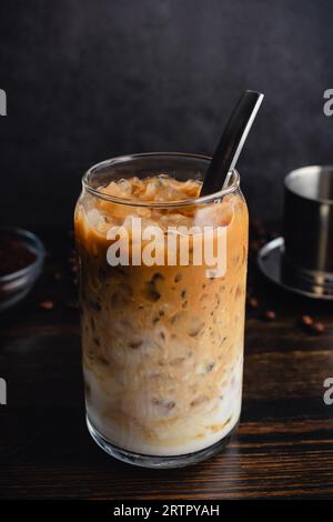 Caffè yogurt vietnamita (sua Chua Cafe o Cà Phê Sữa): Un bicchiere di caffè vietnamita ghiacciato con yogurt strained con un cucchiaio e filtro phin Foto Stock