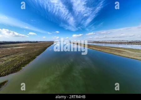 Vista aerea con droni della foce del fiume Tinto. Estuario del Rio Tinto nelle paludi di Huelva con un bel riflesso del cielo Foto Stock