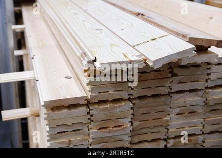 pile di linguette e assi scanalati in legno grezzo, vista ravvicinata delle estremità Foto Stock