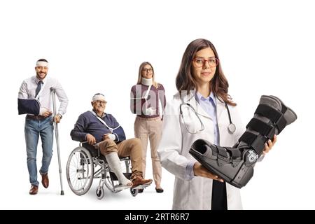 Giovane medico donna che tiene un poggiapiedi e un gruppo di feriti in piedi dietro isolati su sfondo bianco Foto Stock