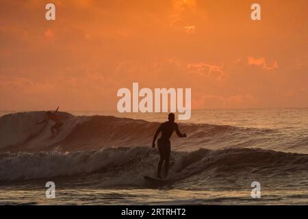 Isola di Palms, Stati Uniti. 14 settembre 2023. I surfisti, visti dall'alba, cavalcano onde più grandi delle normali, mentre l'uragano Lee passa dalla costa portando forti condizioni di surf in tutta la regione bassa del paese, il 14 settembre 2023 a Isle of Palms, South Carolina. Crediti: Richard Ellis/Richard Ellis/Alamy Live News Foto Stock