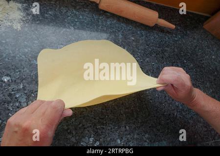 Cucina sveva, preparazione di un sostanzioso strudel di patate, estrazione di impasto di patate crudo, lavorazione, mattarello, piano di lavoro, preparazione di strudel salato con verdure Foto Stock