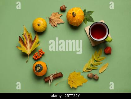 Cornice realizzata con decorazioni in foresta naturale, zucche e tazza di tè su sfondo colorato Foto Stock