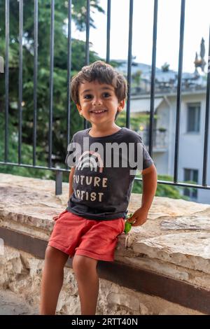 Ritratto di un bambino di due anni che guarda la macchina fotografica mentre si gode le vacanze estive Foto Stock