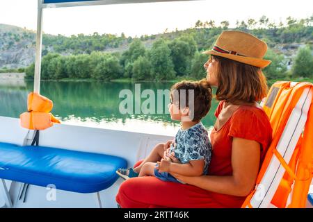 Madre con suo figlio su una barca per un'escursione turistica sul lago Shkoder a Shiroka. Albania Foto Stock