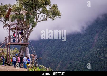 Banos, Ecuador il 18 novembre 2015: I turisti si godono l'altalena gigante nella casa sull'albero Casa del Arbol nelle Ande vicino a Banos, Ecuador. La vista Foto Stock