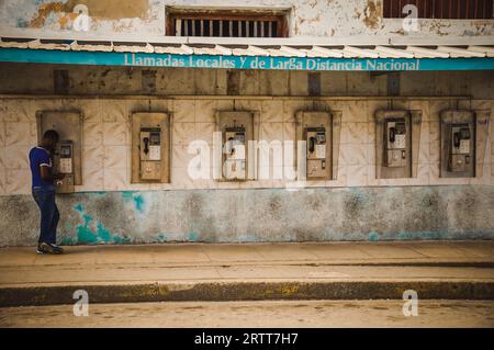 CUBA nel dicembre 2015: Una persona maschile usa un telefono pubblico per effettuare una chiamata. I telefoni pubblici sono gli unici telefoni per molte persone a Cuba Foto Stock