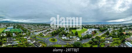 Vista aerea del castello di Monkstown vicino a Dublino, Irlanda, con la torre del cancello restaurata e il suggestivo cielo al tramonto Foto Stock