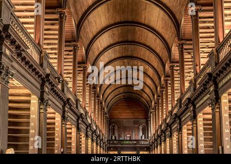 Scaffali in legno e galleria nella classica biblioteca del Trinity College di Dublino Foto Stock