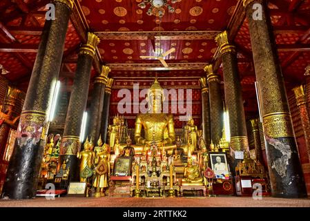 Impressionante statua dorata del Buddha a Wat mai Suwannaphumaham, noto anche come Tempio nuovo, a Luang Prabang. Completamente vuoto nel pomeriggio, dicembre 2014 Foto Stock