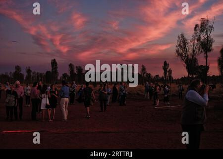 Gli amanti dell'opera si riuniscono nel backstage mentre le nuvole rosa di cirrus si librano su Uluru prima dell'Opera nell'Outback, sotto il Gala inaugurale dell'Opera delle stelle dell'Outback Foto Stock