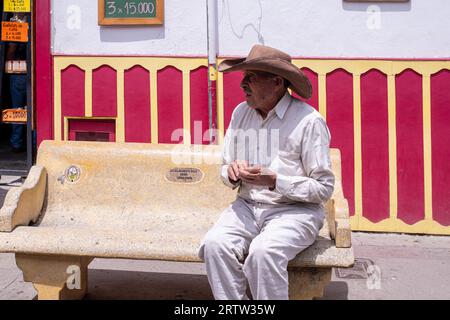 11 luglio 2023: Uomo anziano colombiano a cappello seduto su una panchina nel Salento, Colombia, Sud America Foto Stock