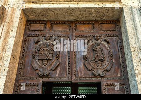 I due stemmi lignei scolpiti sul portale della chiesa di Santa Maria della Carità, detta anche della Scopa, ad Ascoli Piceno. Marche Foto Stock