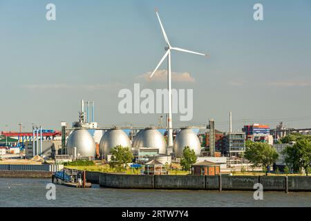 Serbatoio di stoccaggio del gas e grande turbina eolica nella zona portuale di Amburgo, Germania Foto Stock