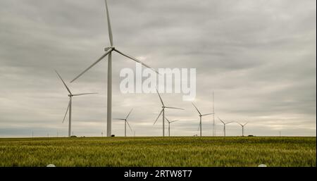 Visione da sogno di cieli turbolenti e turbine eoliche avvolgenti che imbardano e ruotano lentamente con il vento leggero. Foto Stock