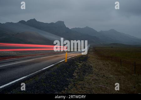 Strada asfaltata che porta alla catena montuosa alla luce del giorno Foto Stock