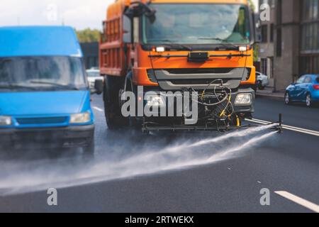 Le macchine municipali per camion irrigano l'asfalto, il processo di disinfezione stradale e la pulizia da polvere e sporco, pulendo le macchine spazzatrici a flussatore wa Foto Stock