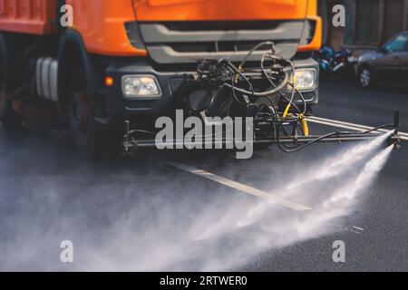 Le macchine municipali per camion irrigano l'asfalto, il processo di disinfezione stradale e la pulizia da polvere e sporco, pulendo le macchine spazzatrici a flussatore wa Foto Stock