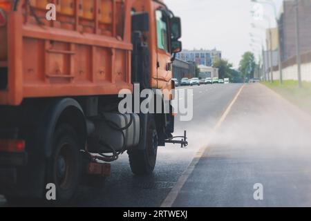 Le macchine municipali per camion irrigano l'asfalto, il processo di disinfezione stradale e la pulizia da polvere e sporco, pulendo le macchine spazzatrici a flussatore wa Foto Stock