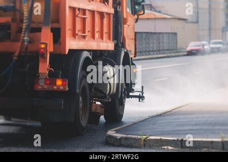 Le macchine municipali per camion irrigano l'asfalto, il processo di disinfezione stradale e la pulizia da polvere e sporco, pulendo le macchine spazzatrici a flussatore wa Foto Stock