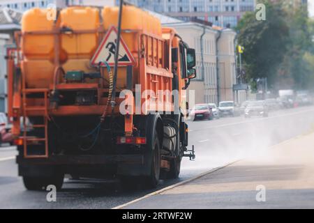 Le macchine municipali per camion irrigano l'asfalto, il processo di disinfezione stradale e la pulizia da polvere e sporco, pulendo le macchine spazzatrici a flussatore wa Foto Stock