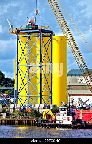 Produzione di nuove turbine eoliche giganti presso lo Smulders Howdon sul cantiere Tyne contro il cielo nuvoloso blu Foto Stock