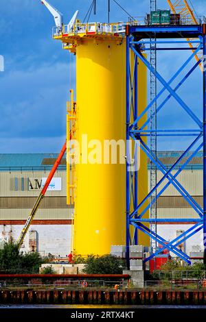 Produzione di nuove turbine eoliche giganti con torri di supporto presso lo Smulders Howdon sul Tyne Yard contro il cielo nuvoloso blu Foto Stock