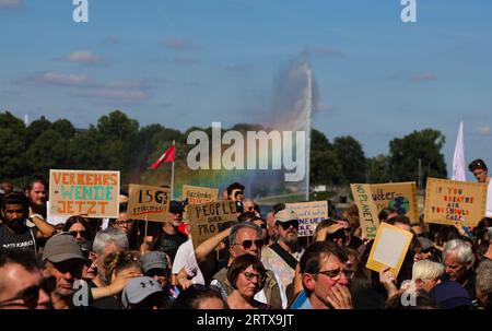 Amburgo, Germania. 15 settembre 2023. Migliaia di persone partecipano a una protesta del movimento per la protezione del clima Fridays for Future sullo Jungfernstieg al Binnenalster. Sullo sfondo, lo spray della fontana Alster forma colori arcobaleno. Con più di 200 manifestazioni e manifestazioni in tutta la Germania, il movimento per la protezione del clima Fridays for Future vuole convincere il governo questo venerdì, come parte dello sciopero globale sul clima sotto lo slogan #EndFossilFuels, a un'uscita più rapida dal carbone, dal petrolio e dal gas. Credito: Christian Charisius/dpa/Alamy Live News Foto Stock