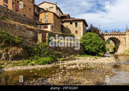 Vista dell'edificio medievale della città vecchia di Potes, del fiume Quivies e del ponte di San Cayetano. Potes, Liébana, Cantabria, Spagna. Foto Stock