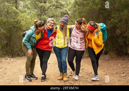 Donne felici con età ed etnie diverse che si divertono a passeggiare nei boschi - concetto di avventura e viaggi per persone Foto Stock