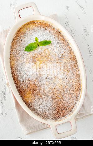 Budino di limone al forno guarnito con zucchero a velo e menta Foto Stock