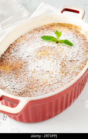 Budino di limone al forno guarnito con zucchero a velo e menta Foto Stock