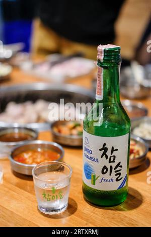 Bangkok, Thailandia - 2 febbraio 2019: Jinro Chamisul Soju con cibo coreano. E' una famosa bevanda distillata limpida e incolore di origine coreana. Jinro Foto Stock