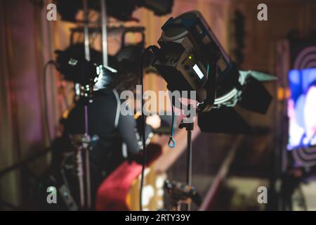 L'assistente del lavoratore di palcoscenico prepara le luci, l'ingegnere della luce, il tecnico dell'illuminazione che regola le luci per concerti e spettacoli musicali nella sala, l'installazione di una professione Foto Stock