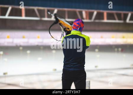 Biatleta con fucile su un poligono di tiro durante l'allenamento di biathlon, sciatori su campo di allenamento nella neve invernale, atleti partecipano alla gara di biathlon Foto Stock