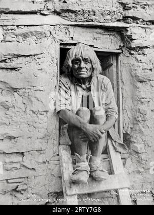 Oraibi, Arizona: 1898 Un uomo Moki si rilassa sulla sua porta. Il fotografo, C. Wharton James, fu poi ucciso a Phoenix da un serpente a sonagli. Foto Stock