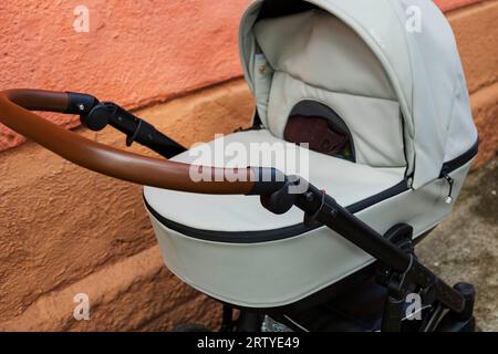 un passeggino vuoto vicino a un muro di mattoni. Un aumento del tasso di natalità. Problemi sociali. Foto Stock