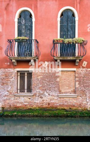 Dettagli da vicino con vetrate veneziane e balcone dall'architettura medievale Foto Stock