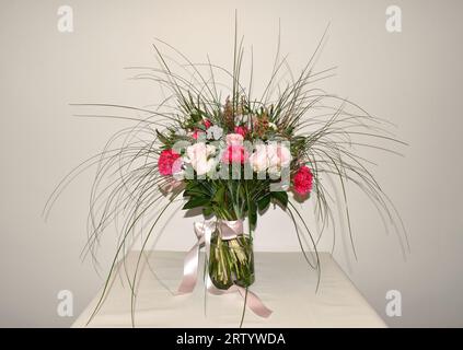Bouquet colorato di vari fiori freschi con rose rosa e garofani rossi Foto Stock