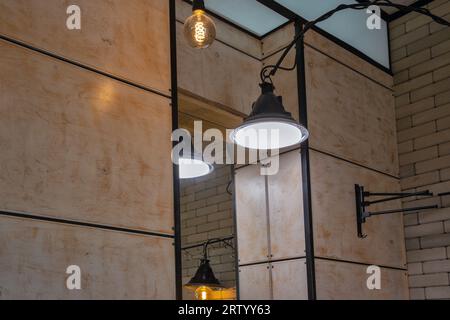 Lampade elettriche in stile minimalista industriale loft contro gli specchi interni Foto Stock