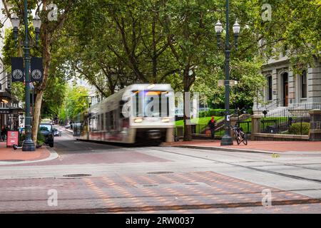 Il treno Trimet MAX passa accanto al Pioneer Courthouse nel centro di Portland, Oregon Foto Stock