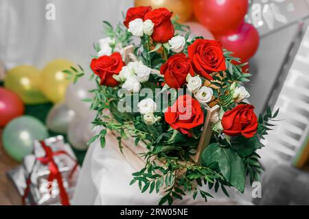 Fiori artificiali, bouquet di rose rosse e bianche, primo piano in un interno festoso. Foto Stock