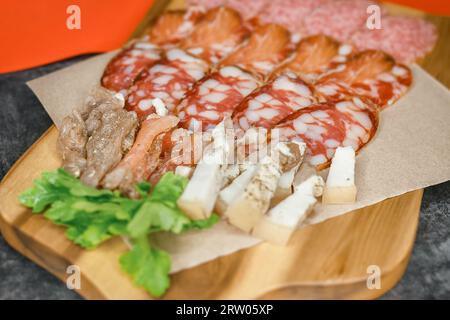 Carne o salsiccia, cibo affettato abbondante e delizioso, antipasto per birra su un asse di legno. Foto Stock